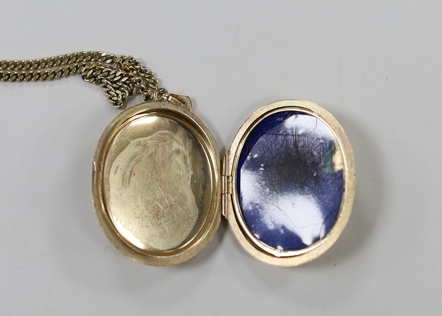 A modern 9ct gold oval locket, 33mm, on a 9ct gold chain, gross weight 16 grams.